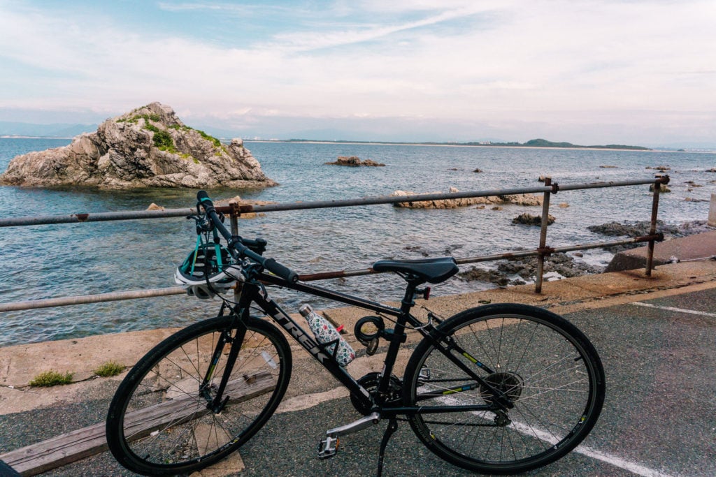 Parked bicycle with a view of the ocean behind it.