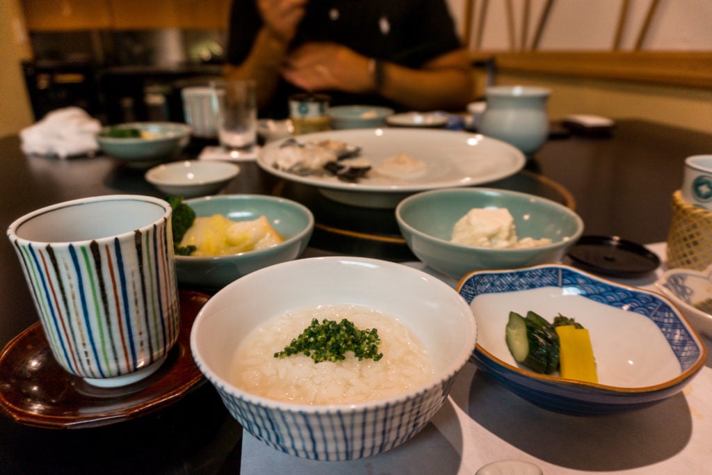 Bowls of rice, vegetables, and blowfish (fugu) hot pot at Hakata Izumi in Fukuoka, Japan