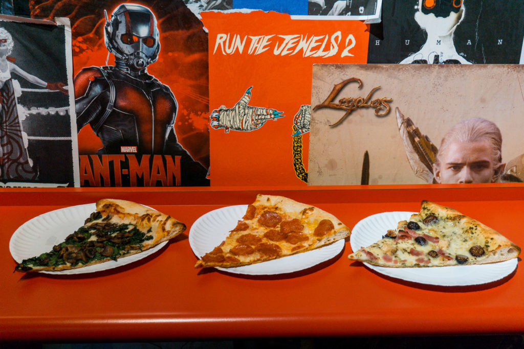 Slices of pizza from Empire Slice House. From left to right: There's a Fungus Among Us (mushroom pizza), Classic Pepperoni Pizza, Figgy Stardust (pesto, chicken, and fig pizza)