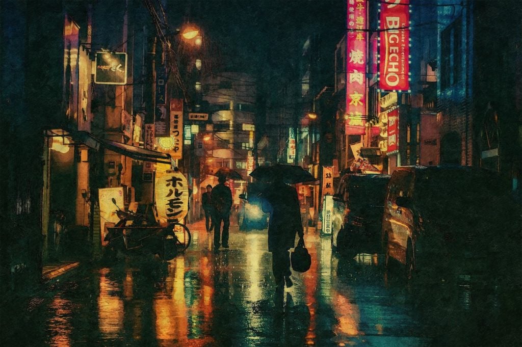 A street in Japan at night with glowing signs. It is raining and the people walking on the street are carrying umbrellas.