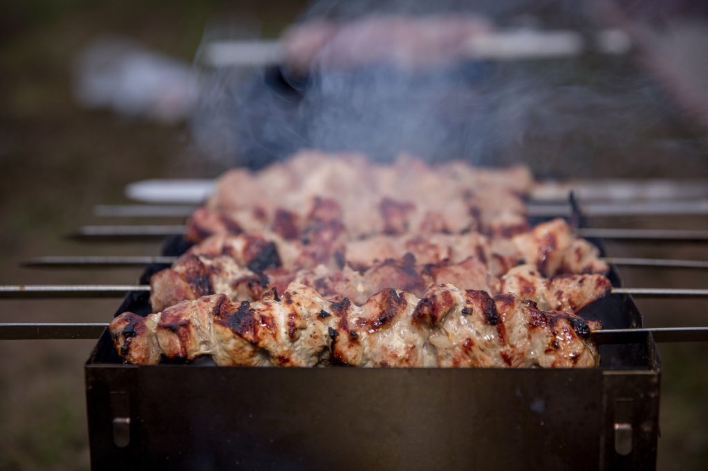 skewers of grilled meat over a grill